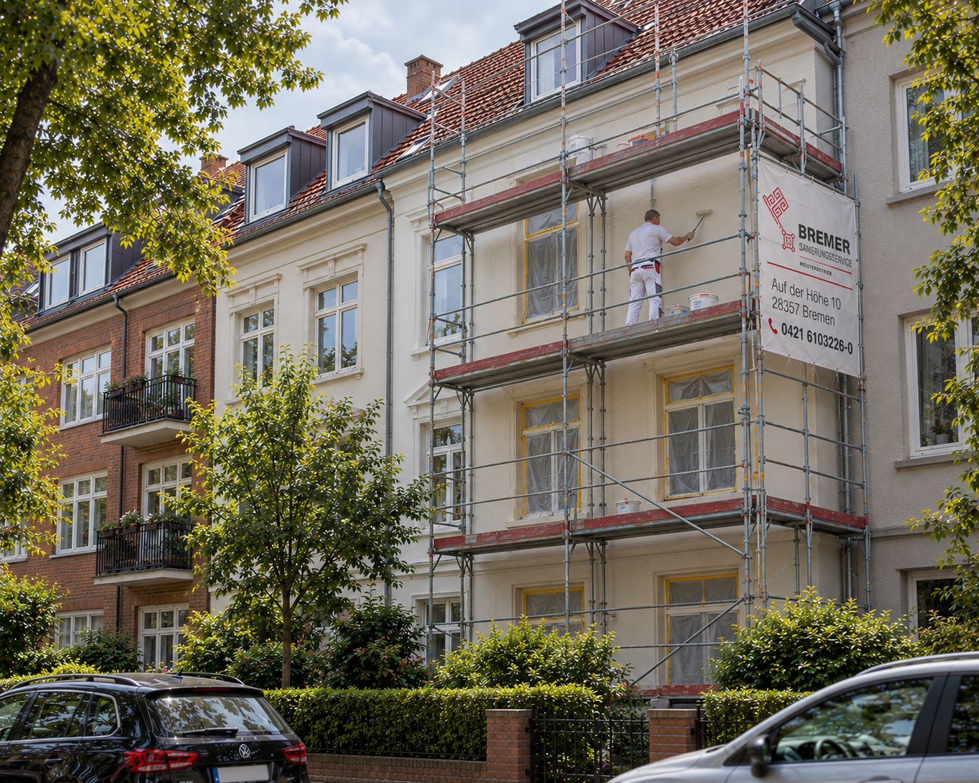Maler auf dem Gerüst an einer Altbaufassade in Bremen, am Gerüst hängt das Banner des Bremer Sanierungsservice